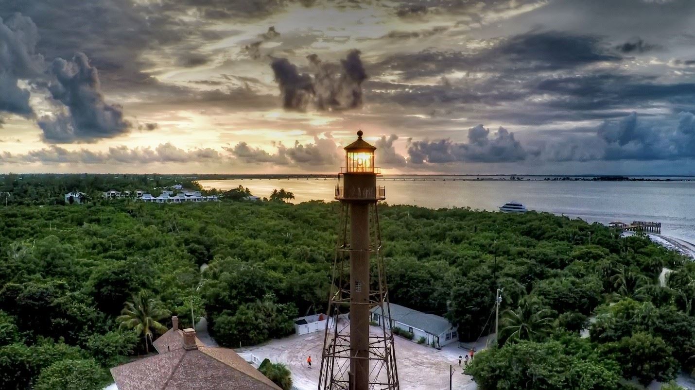 Aerial view of the Sanibel Island Lighthouse at sunset surrounded by tropical greenery and water