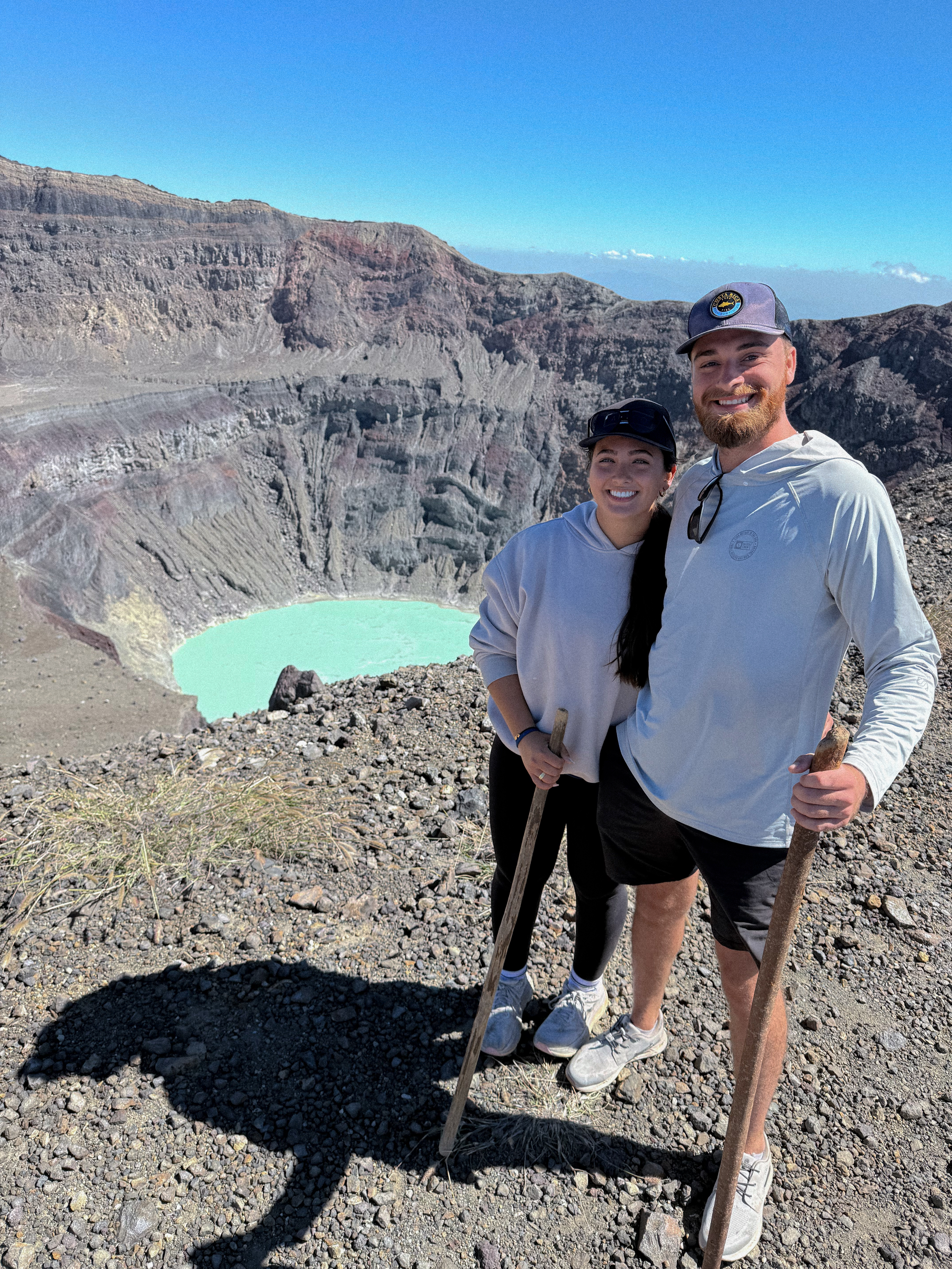 Evan and Corrina smiling together at the top of a volcano crater